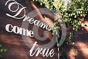 A wooden photozone, decorated with hops, with the inscription: `Dreams come true`.