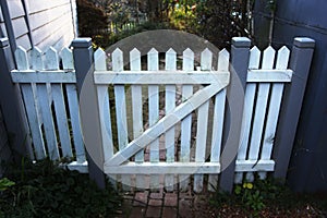 Wooden picket fence gate in white and grey