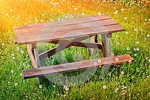 Wooden picnic place on summer green field