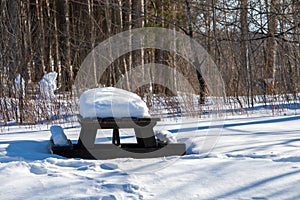 Wooden Picnic Table Covered in Snow