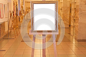 Wooden picture frame on easel in art gallery