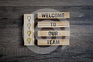 Wooden pieces with light bulbs and message Welcome to our team photo