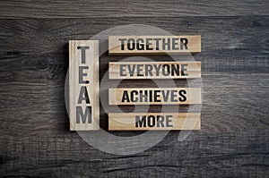 Wooden pieces with Team - Together everyone achieves more on wooden background photo