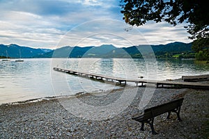 Wooden pier and bench in the beach of Tegernsee lake in Germany