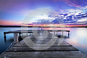 Wooden pier on a blue lake whit sunset