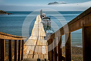 A Wooden Pier with boats in the background