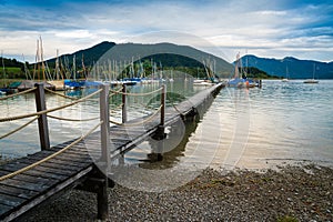 Wooden pier and boats in the beach of Tegernsee lake in Germany