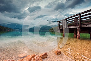 Wooden pier at Bohinj lake on cloudy autumn day