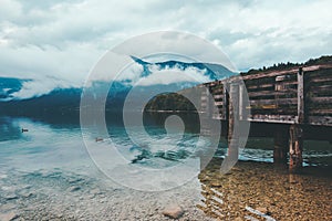 Wooden pier at Bohinj lake on cloudy autumn day