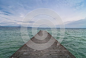 Wooden pier and cloudy sky over Garda lake - Italy