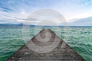 Wooden pier and cloudy sky over Garda lake - Italy