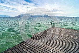 Wooden pier and cloudy sky over Garda lake - Italy