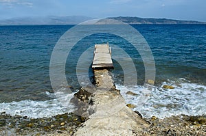Wooden pier connected by a concrete passage on the bottom there are islands in the sea there is none