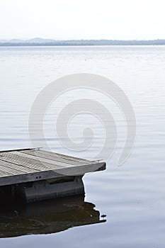 wooden pier detail on dark water. Wooden dock detail.