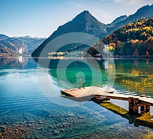 Wooden pier in a fishing village. Wonderful sunny day on Grundlsee lake. Beautiful autumn view of Eastern Alps, Liezen District of