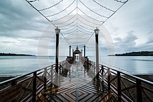 Wooden pier in Frutillar, Chile with the view of the Llanquihue lake under the cloudy sky