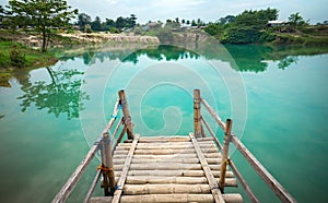 Wooden Pier on Green Blue Lagoon, Tropical Paradise. Traditional Bamboo Pier or Jetty on Lakeside. Concept of New Beginning of Exp