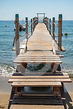 Wooden pier for guests and yachts on legendary Pampelonne beach near Saint-Tropez, summer vacation on white sandy beaches of