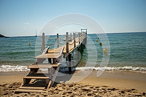 Wooden pier for guests and yachts on legendary Pampelonne beach near Saint-Tropez, summer vacation on white sandy beaches of