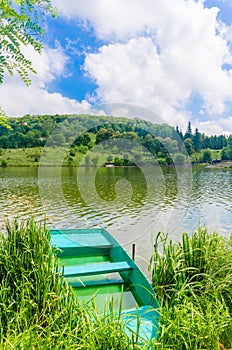 Wooden pier or jetty and a boat on lake sunset and sky reflection water.