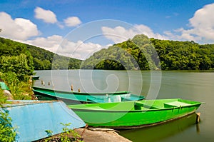 Wooden pier or jetty and a boat on lake sunset and sky reflection water.