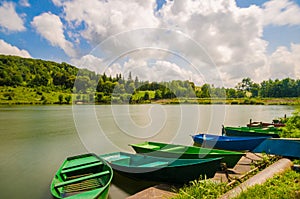 Wooden pier or jetty and a boat on lake sunset and sky reflection water.