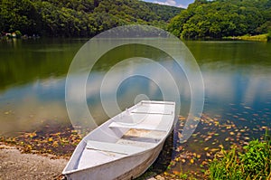 Wooden pier or jetty and a boat on lake sunset and sky reflection water.