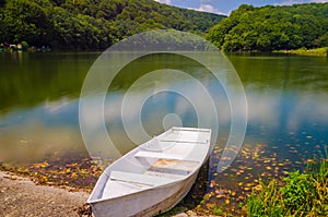 Wooden pier or jetty and a boat on lake sunset and sky reflection water.