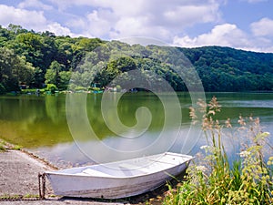 Wooden pier or jetty and a boat on lake sunset and sky reflection water.