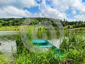 Wooden pier or jetty and a boat on lake sunset and sky reflection water.