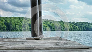 Wooden pier or jetty with a metal railing leading into the lake