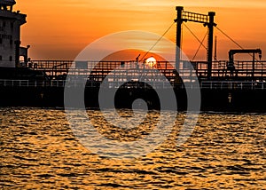 Wooden pier or jetty remains on blue lake sunset and sky reflection water,