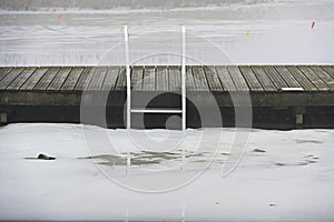 wooden pier and ladder on the lake in winter