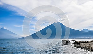 Wooden pier at Lake Atitlan on the beach in Panajachel, Guatemala. With beautiful landscape scenery of volcanoes Toliman, Atitlan