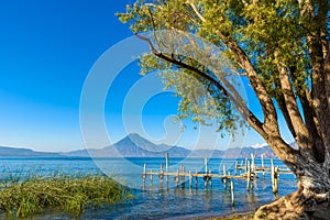 Wooden pier at Lake Atitlan on the shore at Panajachel, Guatemala.  With beautiful landscape scenery of volcanoes Toliman, Atitlan photo