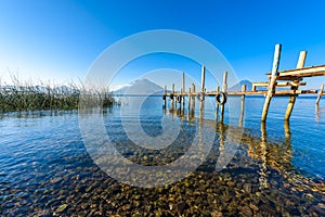 Wooden pier at Lake Atitlan on the shore at Panajachel, Guatemala.  With beautiful landscape scenery of volcanoes Toliman, Atitlan