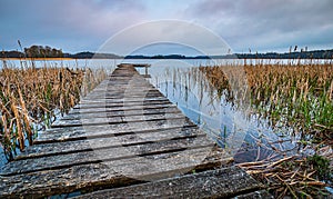 Wooden pier on a lake in Mazury Region, Poland during early morning sunrise photo