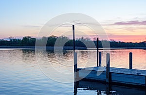 Wooden pier on lake at sunset