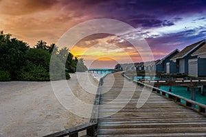 A wooden pier leading to water lodges in the Maldives