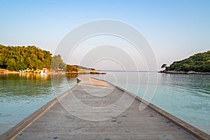 Wooden pier in the turquoise sea with blue sky