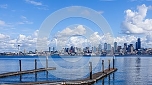 Wooden pier over a sea with the city of Seattle, USA under the beautiful clouds in the background