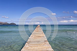 A wooden pier at Playa de Muro beach in Mallorca