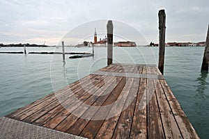 Wooden pier with poles at Grand Canal waterway in Venice