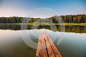 Wooden pier on a quiet lake in the morning