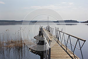 a wooden pier on a quiet serene lake. Peaceful rural landscape