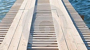 Wooden pier in the sea with clear blue water.