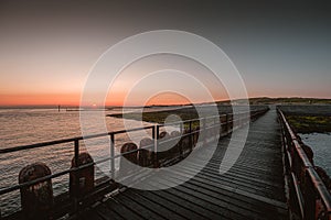 Wooden pier by the sea under the beautiful sunset in Westkapelle, Netherlands