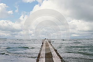 Wooden pier on the seashore with stormy sea