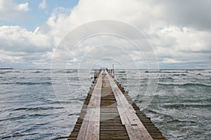 Wooden pier on the seashore with stormy sea