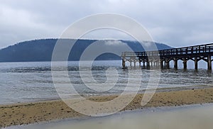 wooden pier for ships in rainy weather on the Angara River near Lake Baikal